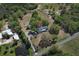 Aerial view of property featuring pond, home, outbuildings and fenced pasture at 7435 Redwing Rd, Groveland, FL 34736