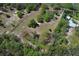 A large peaceful lot featuring mature landscaping, a home, and additional structures at 7435 Redwing Rd, Groveland, FL 34736