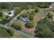 Aerial perspective of property showcasing house, pond, pasture, and outbuildings at 7435 Redwing Rd, Groveland, FL 34736