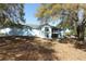 Large backyard with mature trees and patio at 7435 Redwing Rd, Groveland, FL 34736