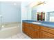 Primary bathroom featuring a soaking tub, wooden cabinets, and a spacious vanity at 7435 Redwing Rd, Groveland, FL 34736