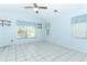 Bedroom with tile flooring, bright blue walls, window with blinds, and ceiling fan at 7435 Redwing Rd, Groveland, FL 34736