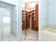 Walk-in closet with custom wood shelving adjacent to primary bedroom and bathroom at 7435 Redwing Rd, Groveland, FL 34736