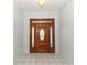 Spacious entryway features tile flooring and a decorative wood door at 7435 Redwing Rd, Groveland, FL 34736