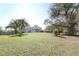 Exterior shot of the house on a partially cleared grass-covered lot at 7435 Redwing Rd, Groveland, FL 34736