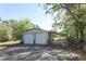 Exterior view of detached two-car garage with lean-to carport and concrete driveway at 7435 Redwing Rd, Groveland, FL 34736