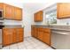 Kitchen featuring tile flooring, wood cabinets, stone countertops, and stainless steel dishwasher at 7435 Redwing Rd, Groveland, FL 34736