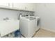 Laundry room featuring stainless washer/dryer, wash sink, and wire shelving for storage at 7435 Redwing Rd, Groveland, FL 34736