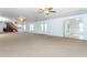 Large living room features carpet, doors, and stairs at 7435 Redwing Rd, Groveland, FL 34736