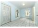 Sunlit living room with tiled floor, windows and glass door with lace curtains at 7435 Redwing Rd, Groveland, FL 34736