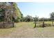 Spacious and clear grass-covered homesite with mature trees and fence at 7435 Redwing Rd, Groveland, FL 34736