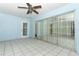 Enclosed lanai featuring tile flooring, ceiling fan, and sliding glass doors to the backyard at 7435 Redwing Rd, Groveland, FL 34736