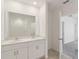 Modern bathroom with double sinks, large mirror, and tiled shower at 800 Griffon Ave, Lake Alfred, FL 33850