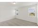 Bright bedroom with neutral carpet and fresh white walls is illuminated by natural light from two windows at 800 Griffon Ave, Lake Alfred, FL 33850