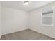 Bedroom features a window providing natural light, neutral carpet, and fresh white walls at 800 Griffon Ave, Lake Alfred, FL 33850