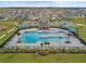 Aerial view of a community pool with a splash pad, lounge chairs, and ample parking at 800 Griffon Ave, Lake Alfred, FL 33850