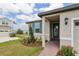 Inviting single-story home with manicured landscaping, brick walkway, and covered front entry at 800 Griffon Ave, Lake Alfred, FL 33850