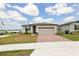 Charming single-story home featuring a two-car garage, brick driveway, and a well-maintained lawn at 800 Griffon Ave, Lake Alfred, FL 33850