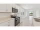 Modern kitchen with stainless steel oven, microwave, and quartz countertops and view to backyard at 800 Griffon Ave, Lake Alfred, FL 33850