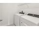 Laundry room with white washer and dryer units and wire shelving for storage at 800 Griffon Ave, Lake Alfred, FL 33850