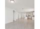 Open-concept living area flows into kitchen with stainless appliances, white cabinets and tiled floor at 800 Griffon Ave, Lake Alfred, FL 33850