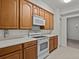 Well-lit kitchen with wooden cabinets, modern white appliances, and tile flooring at 8338 Quimby Cir, Davenport, FL 33896