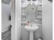 Stylish half bath featuring a pedestal sink with modern fixtures and decorative shiplap accent wall at 1028 Orange Cosmos Blvd, Davenport, FL 33837