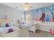 Bright bedroom featuring two twin beds, fan, carpeted floor, and Frozen themed decor at 1028 Orange Cosmos Blvd, Davenport, FL 33837