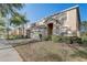 Charming two-story home featuring a two-car garage, arched entryway, and beautifully maintained lawn at 1028 Orange Cosmos Blvd, Davenport, FL 33837