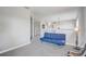 Hallway featuring plush carpet, neutral walls, and a comfortable blue loveseat for relaxation at 1028 Orange Cosmos Blvd, Davenport, FL 33837