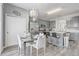 Charming kitchen with gray cabinets, stainless appliances, island seating, and a glass top dining table set at 1028 Orange Cosmos Blvd, Davenport, FL 33837