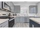 Modern kitchen featuring sleek gray cabinets, stainless steel appliances, and ample counter space at 1028 Orange Cosmos Blvd, Davenport, FL 33837