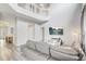 Sun-filled living room with vaulted ceilings, gray leather couch, and entertainment center at 1028 Orange Cosmos Blvd, Davenport, FL 33837