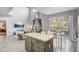 Open-concept living room with a modern kitchen island, and a view of a screened in porch at 1028 Orange Cosmos Blvd, Davenport, FL 33837