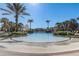 A serene community pool lined with palm trees and lush landscaping on a sunny day at 1028 Orange Cosmos Blvd, Davenport, FL 33837