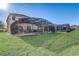 View of home's screened in pool and backyard, with a lush, green lawn on a sunny day at 1028 Orange Cosmos Blvd, Davenport, FL 33837