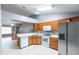 Well-lit kitchen featuring tile floors, wooden cabinets, white appliances, and an open view of the living area at 109 Reserve Cir # 201, Oviedo, FL 32765