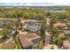An aerial view shows the proximity of this home to a lake, tree-lined roads, and nearby retail at 111 Woodstream Ct, Maitland, FL 32751