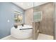 Bright bathroom showcases a soaking tub with outdoor view and tiled glass shower at 111 Woodstream Ct, Maitland, FL 32751