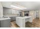 Bright kitchen with an island, stainless steel appliances, gray cabinets, and wood-look flooring at 111 Woodstream Ct, Maitland, FL 32751