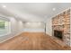 Bright living room with hardwood floors, a cozy brick fireplace, and elegant lighting at 111 Woodstream Ct, Maitland, FL 32751
