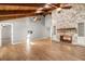 Spacious living room featuring a stone fireplace, vaulted ceiling with beams, and wood-look flooring at 111 Woodstream Ct, Maitland, FL 32751