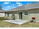 Backyard featuring a patio, egg chair, and red grill on green grass at 1137 Stratton Ave, Groveland, FL 34736