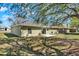 Large backyard with a patio, egg chair, grill, and lots of trees at 1137 Stratton Ave, Groveland, FL 34736