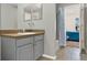 Neutral bathroom with grey vanity and walk in shower next to bedroom at 1137 Stratton Ave, Groveland, FL 34736