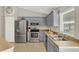 Updated kitchen featuring stainless steel appliances, gray cabinets, and modern fixtures at 1137 Stratton Ave, Groveland, FL 34736
