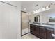 Bathroom featuring a glass shower, double vanity with dark cabinets, and ample lighting at 11926 Verrazano Dr, Orlando, FL 32836
