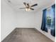 Bedroom featuring ceiling fan and window with blue curtains at 11926 Verrazano Dr, Orlando, FL 32836