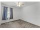 A neutral toned bedroom showcasing a ceiling fan and window with gray curtains at 11926 Verrazano Dr, Orlando, FL 32836