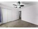 A bright bedroom features a ceiling fan, closet, and neutral carpet at 11926 Verrazano Dr, Orlando, FL 32836